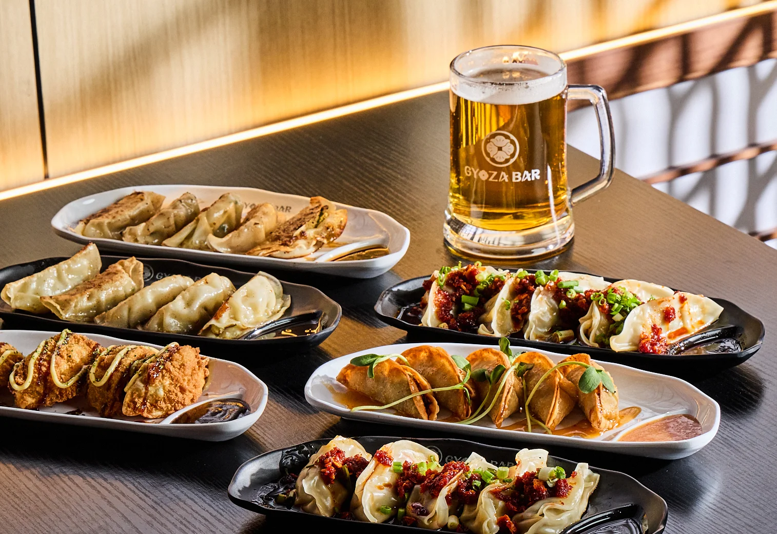 Assorted Japanese gyoza dumplings with beer in a modern restaurant setting