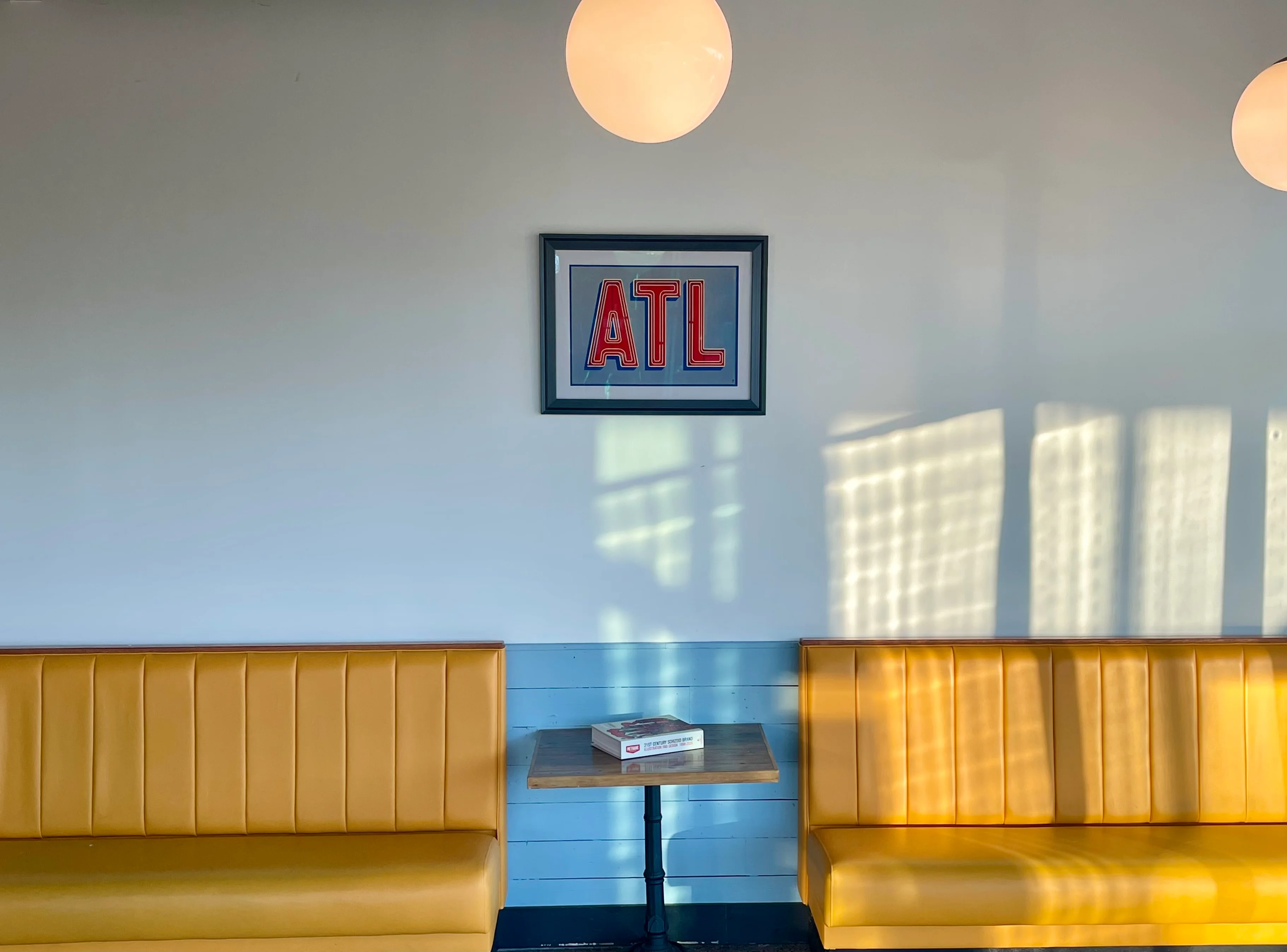 Cozy restaurant interior with yellow seating and framed art