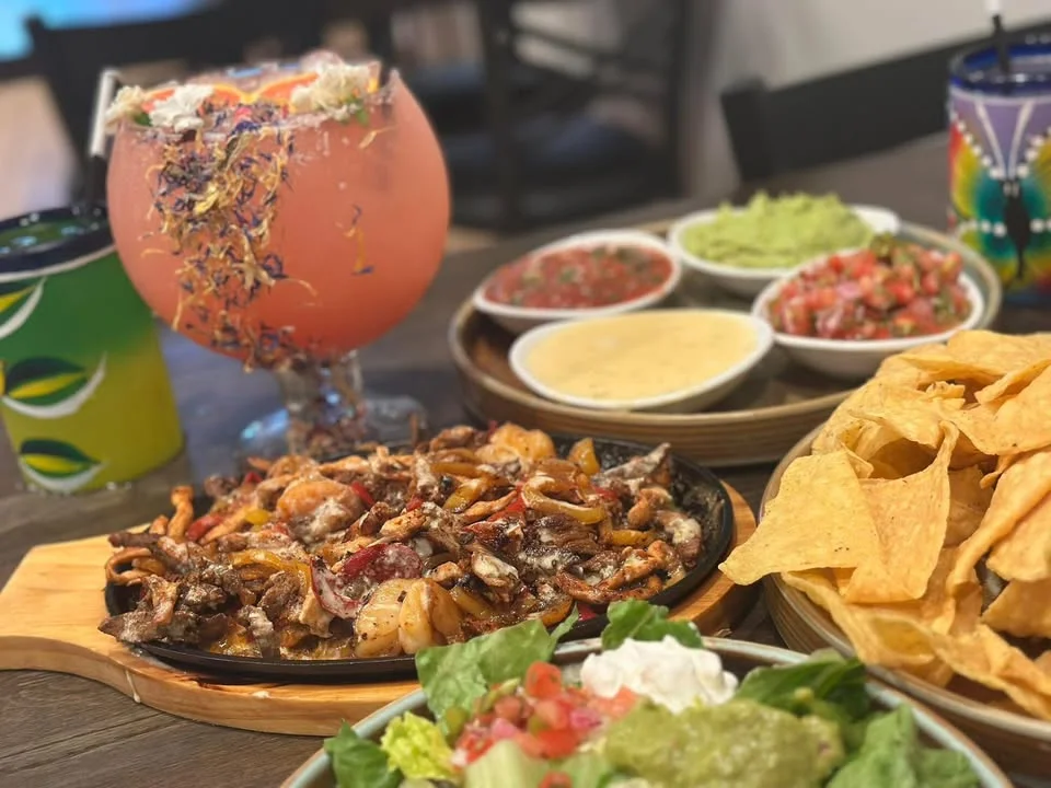 Sizzling fajitas platter with vibrant sides and colorful drinks