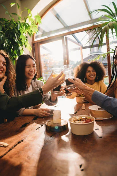 Friends toasting drinks at a cozy restaurant table