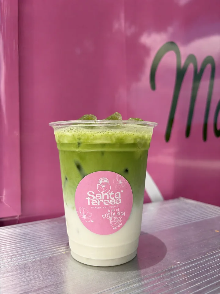 A layered green drink featuring matcha, served cold with a creamy base in a clear cup.