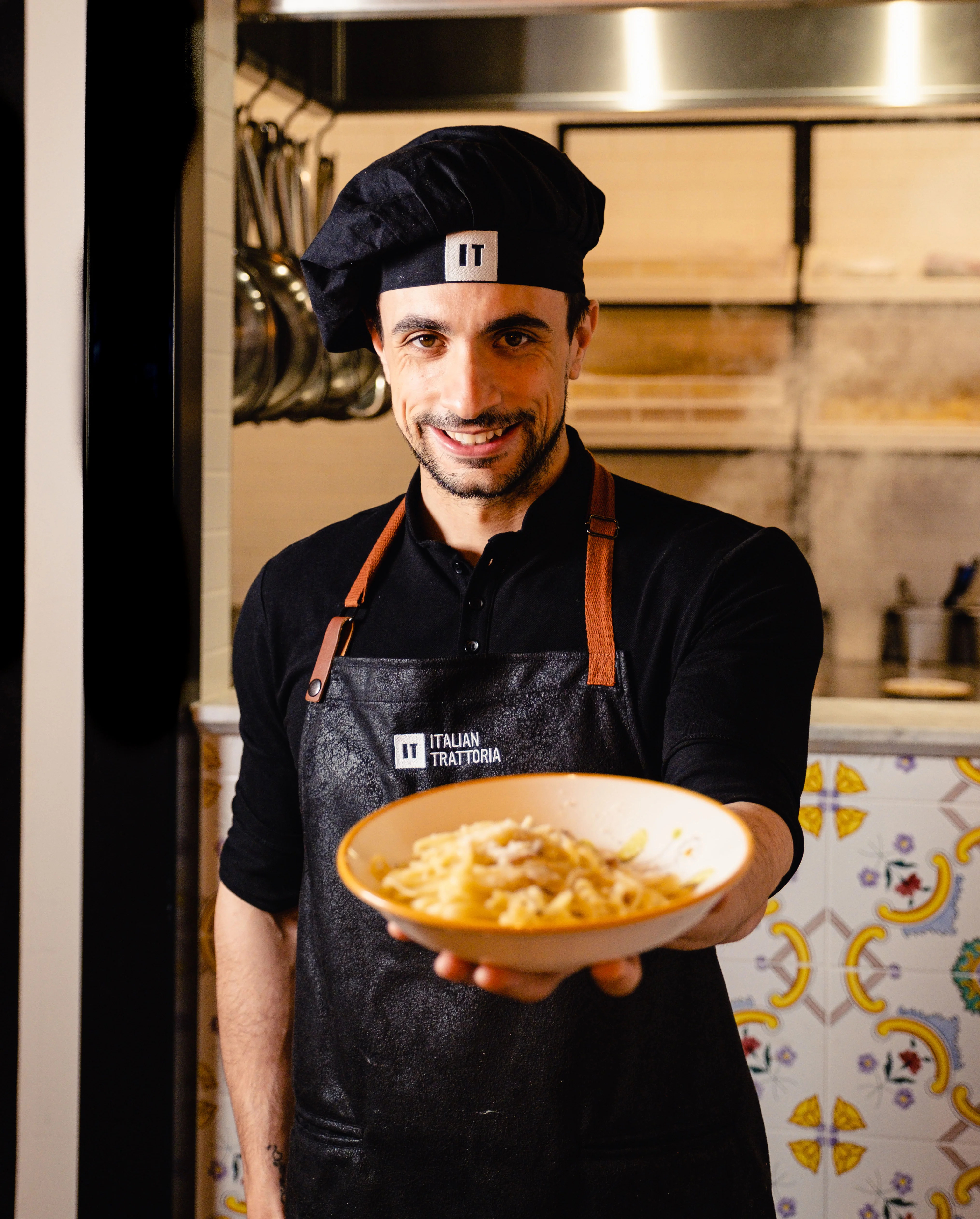 Chef presenting creamy Italian carbonara in a restaurant