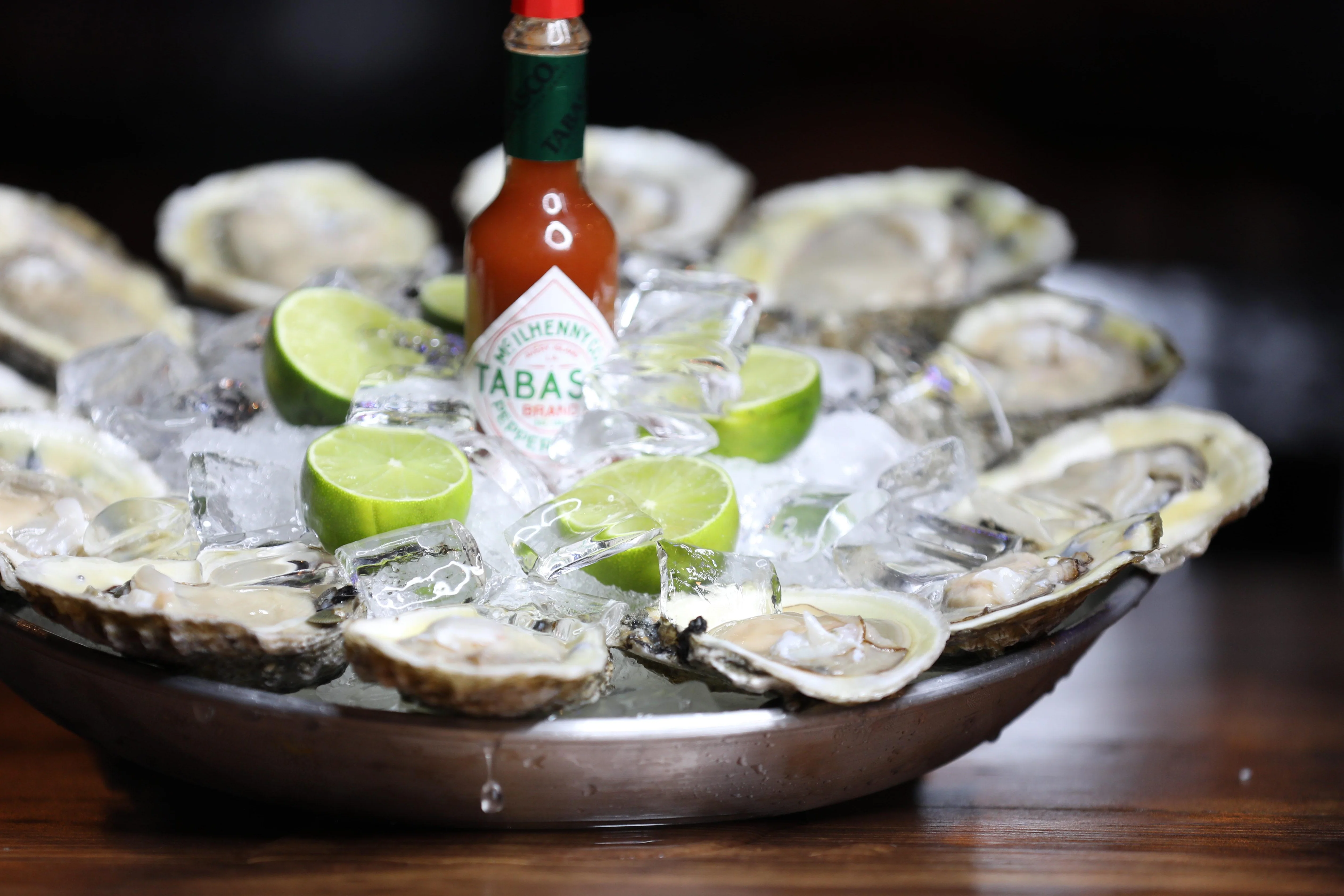 Fresh oysters on ice with lime and hot sauce