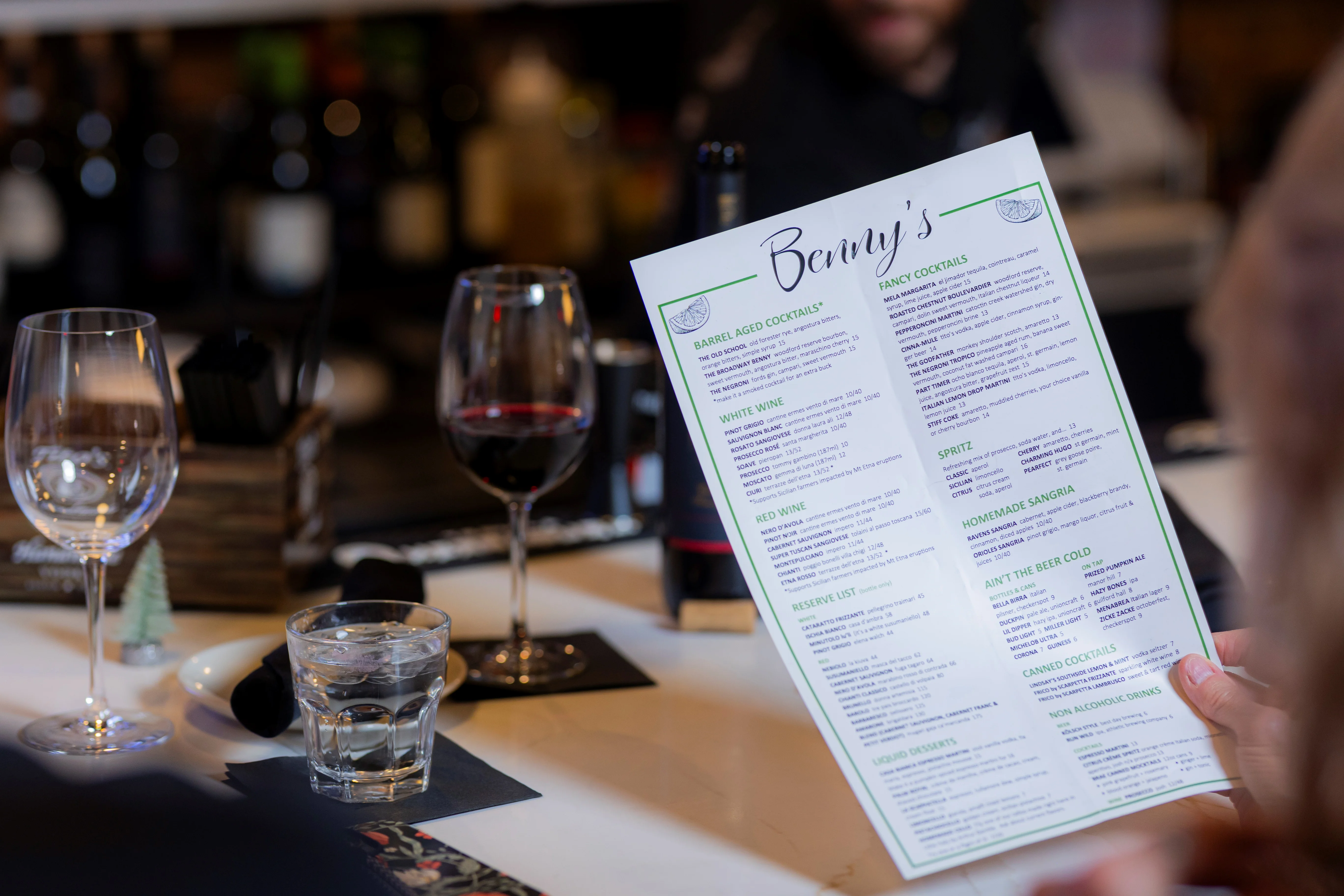 Cocktail menu at a modern bar with wine glasses