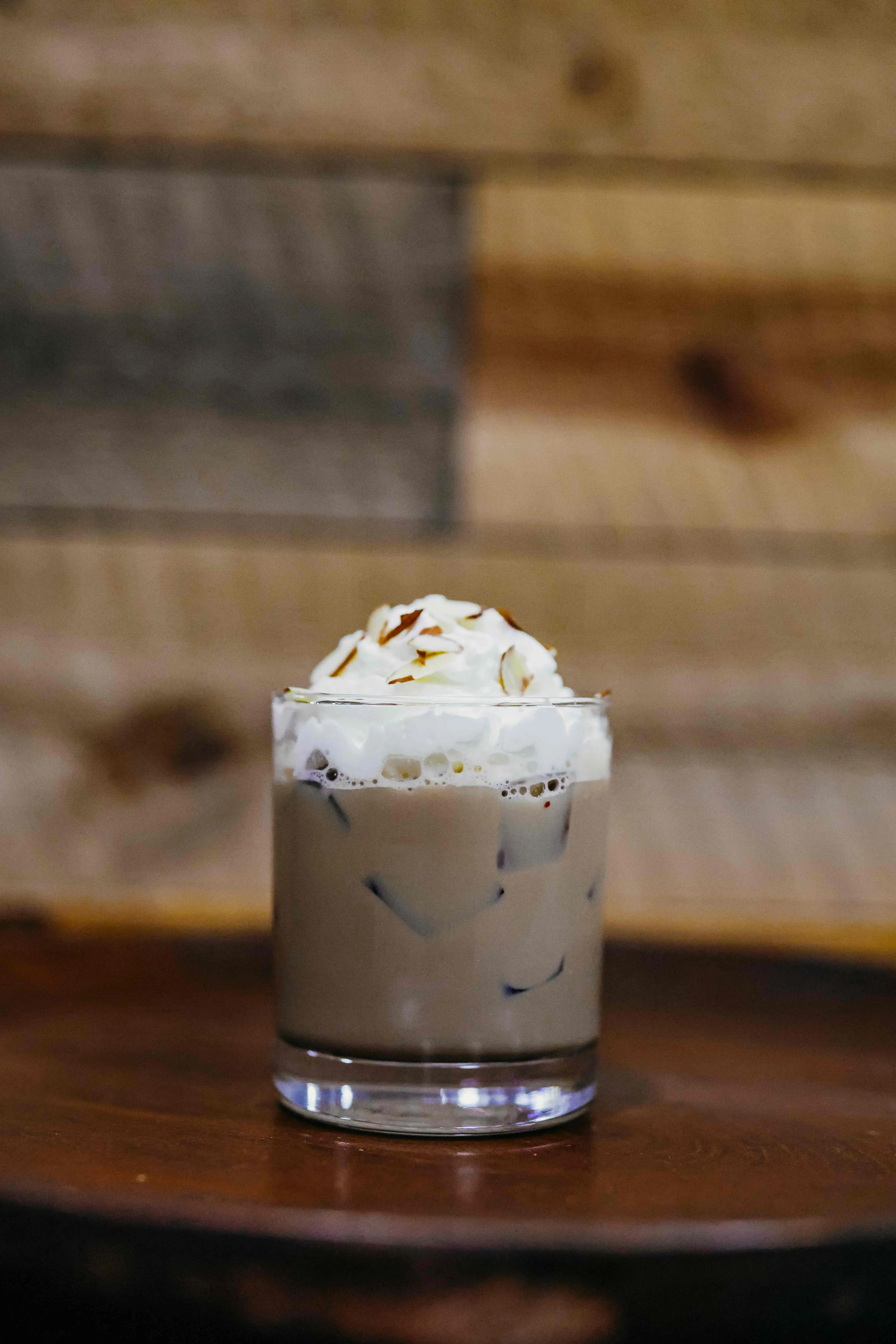Iced coffee drink topped with whipped cream and almonds