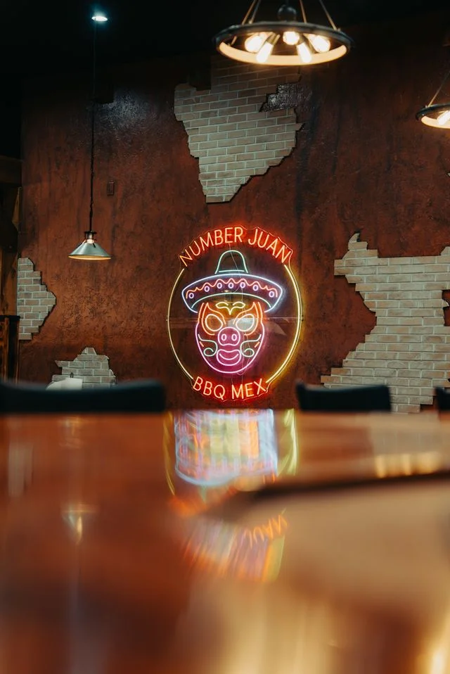 Cozy restaurant interior with neon BBQ sign and rustic decor