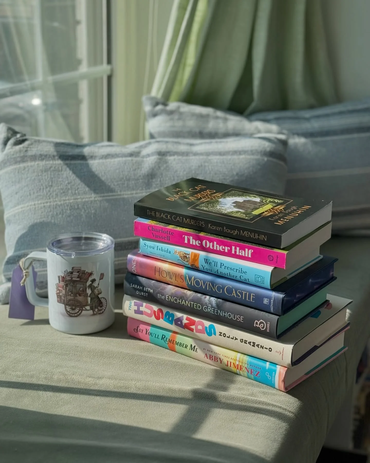 Cozy coffee shop setting with books and coffee on a table.