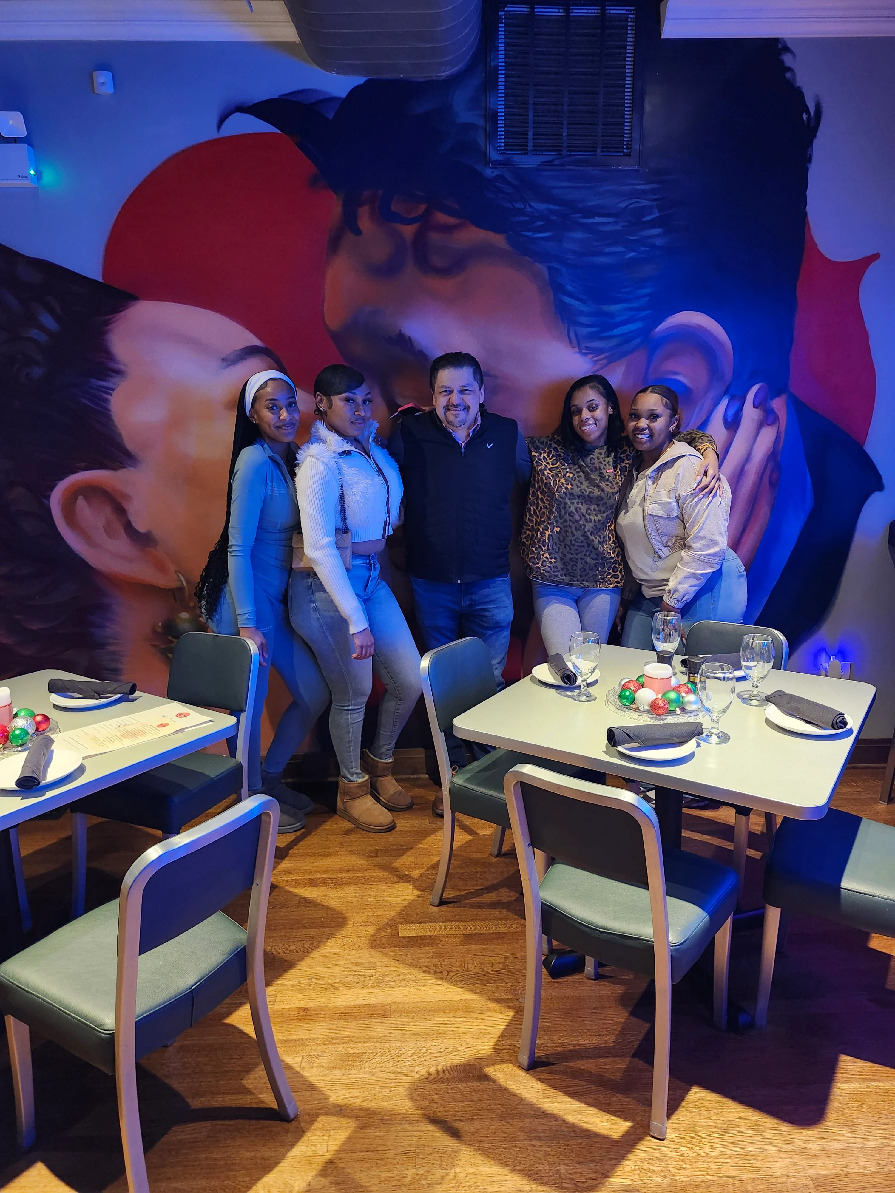 Group of friends enjoying a vibrant restaurant interior with mural art