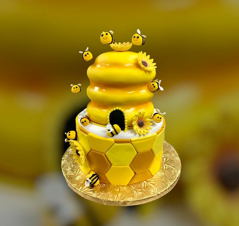 Whimsical bee-themed birthday cake with honeycomb design