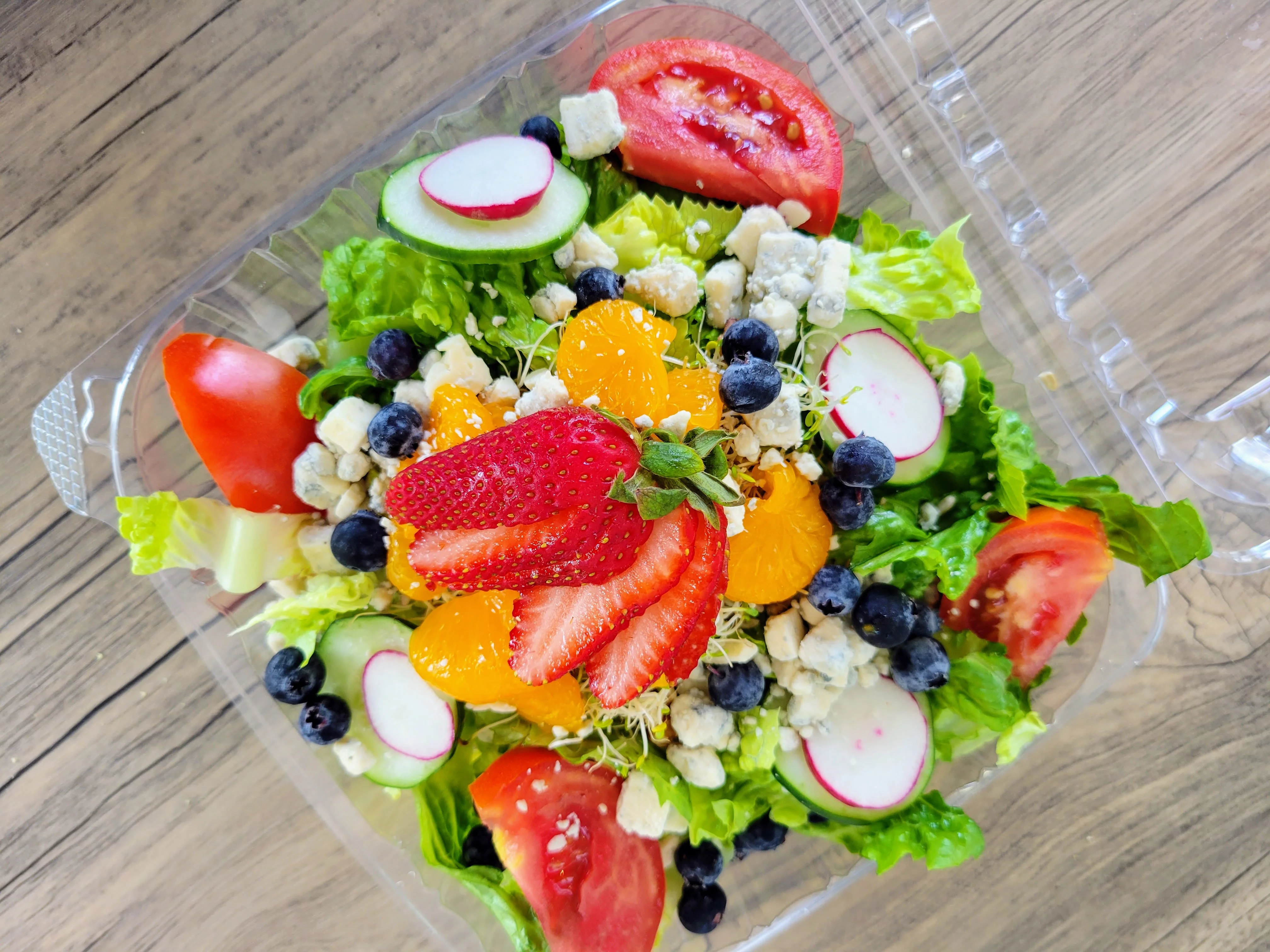 Colorful garden salad with fresh fruits and greens