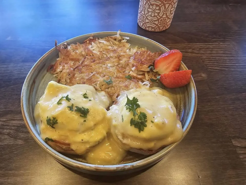 Classic Eggs Benedict with hash browns and strawberries