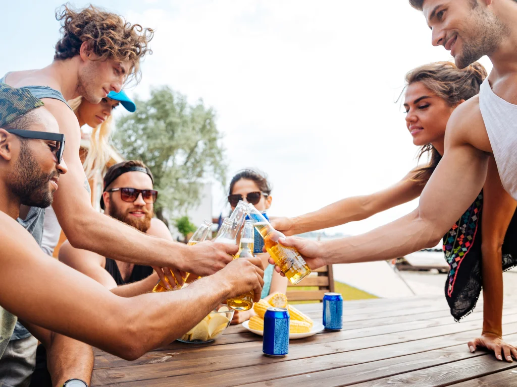 Group of young people cheers with drinks