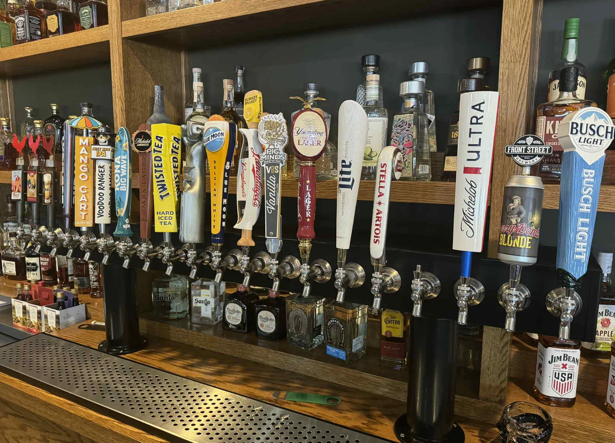 A bar counter at Dunks Bar & Grill featuring multiple beer taps, liquor bottles on shelves, and a TV overhead.