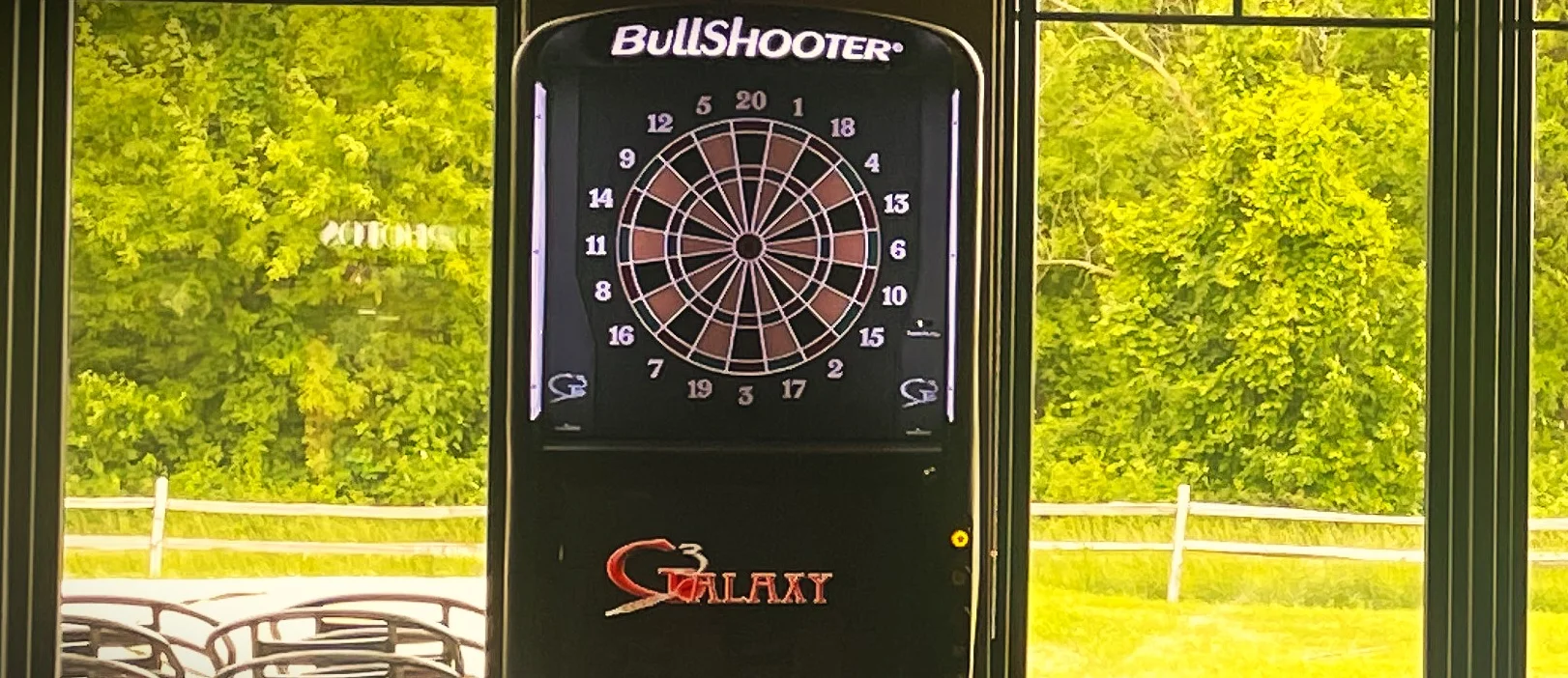 Dart machines in a cozy restaurant with large windows