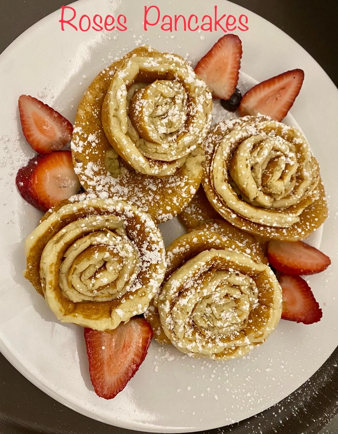 Artistic rose-shaped pancakes served with strawberries
