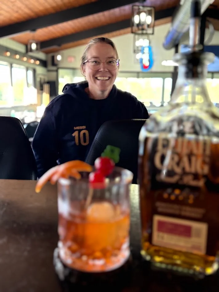 traditional old fashion made with Elija Graig bourbon, with women smiling in background 