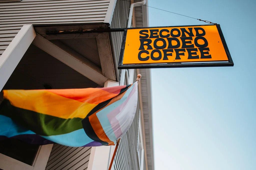 Sign for Second Rodeo Coffee with a rainbow pride flag waving