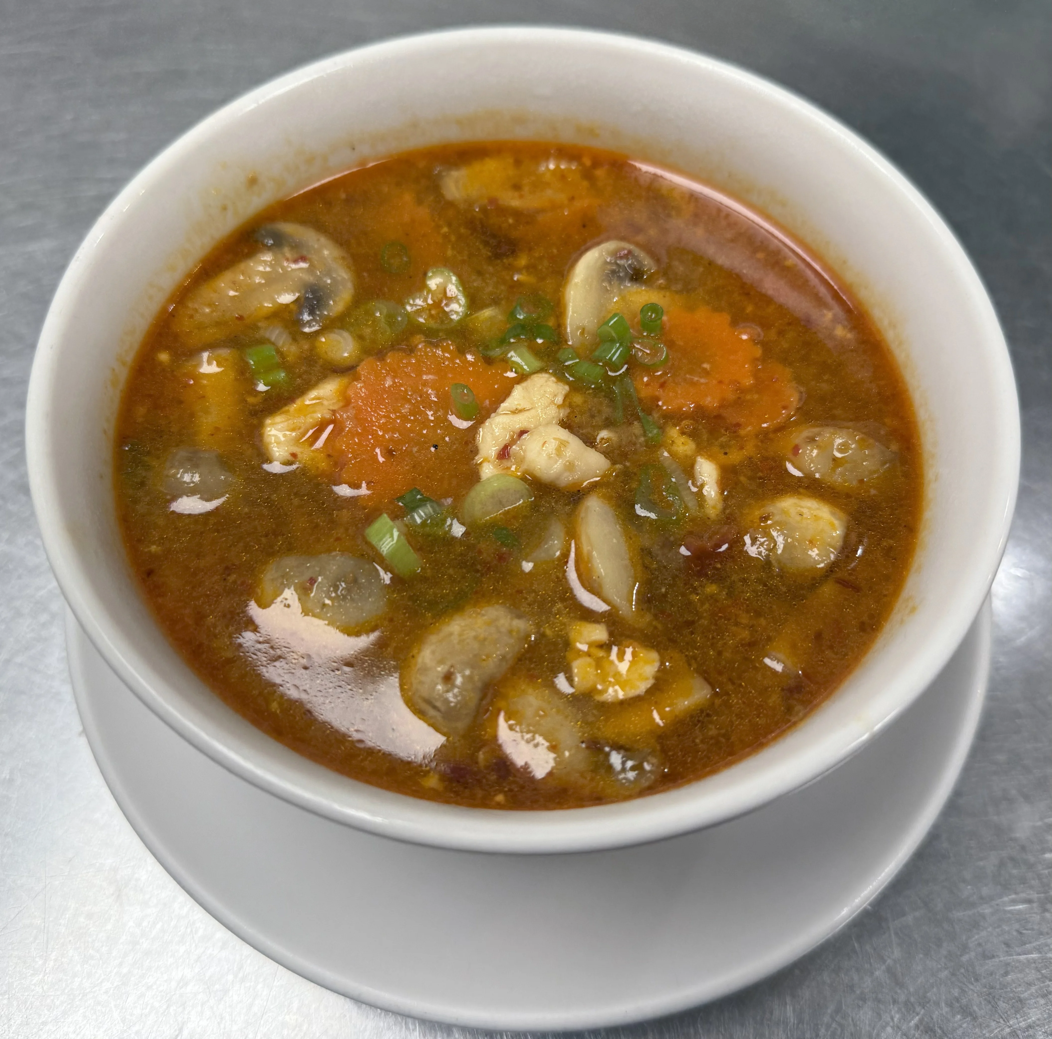 Spicy Thai tom yum soup with seafood and herbs