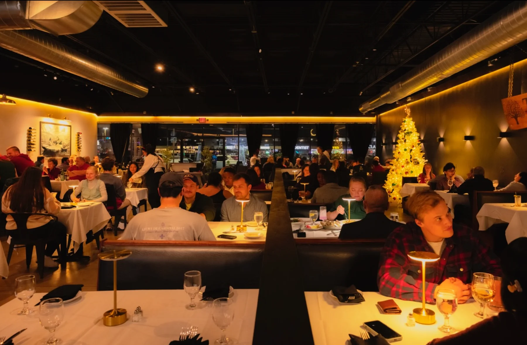 Busy restaurant interior with festive decor and diners enjoying meals.