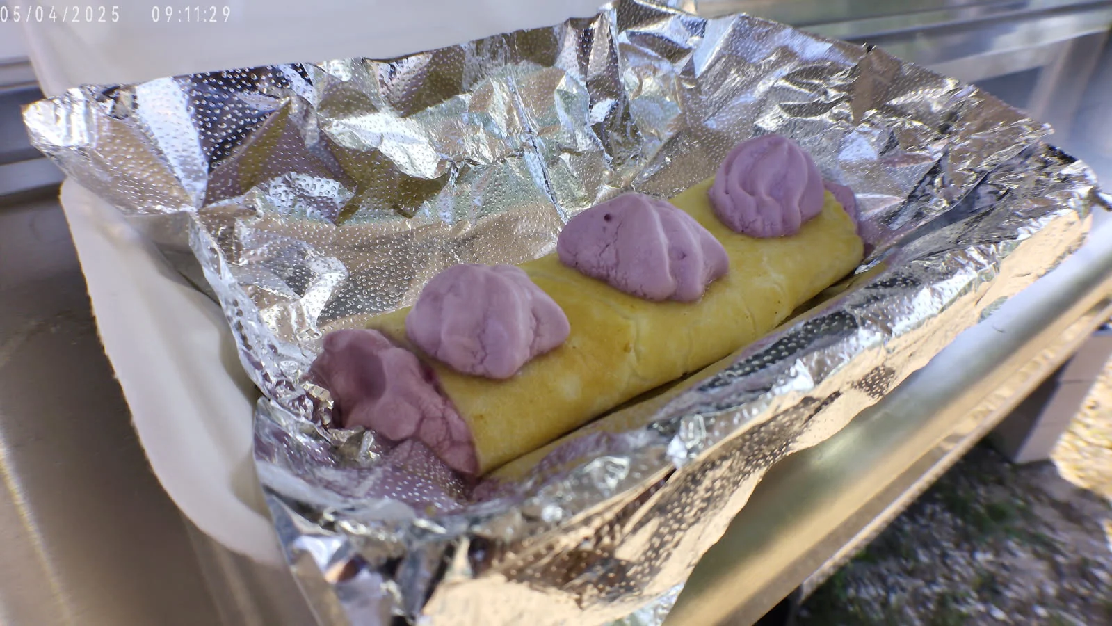Delicious Thai dessert with sweet purple coconut cream on a rolled pancake