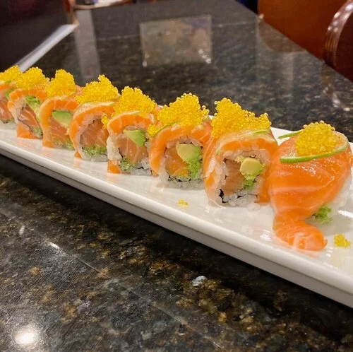 Japanese sushi roll topped with salmon and fish roe