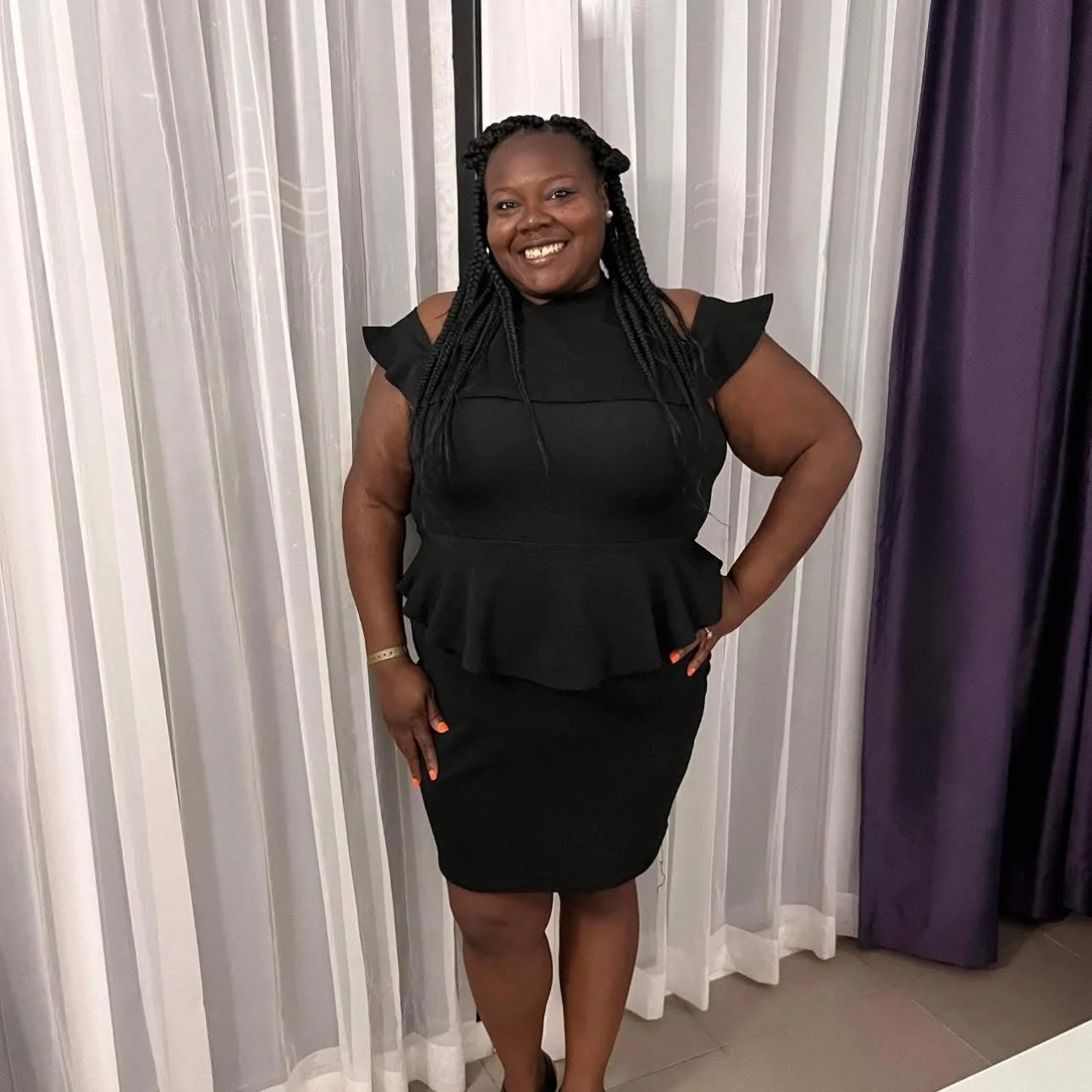Woman in a stylish black dress posing confidently
