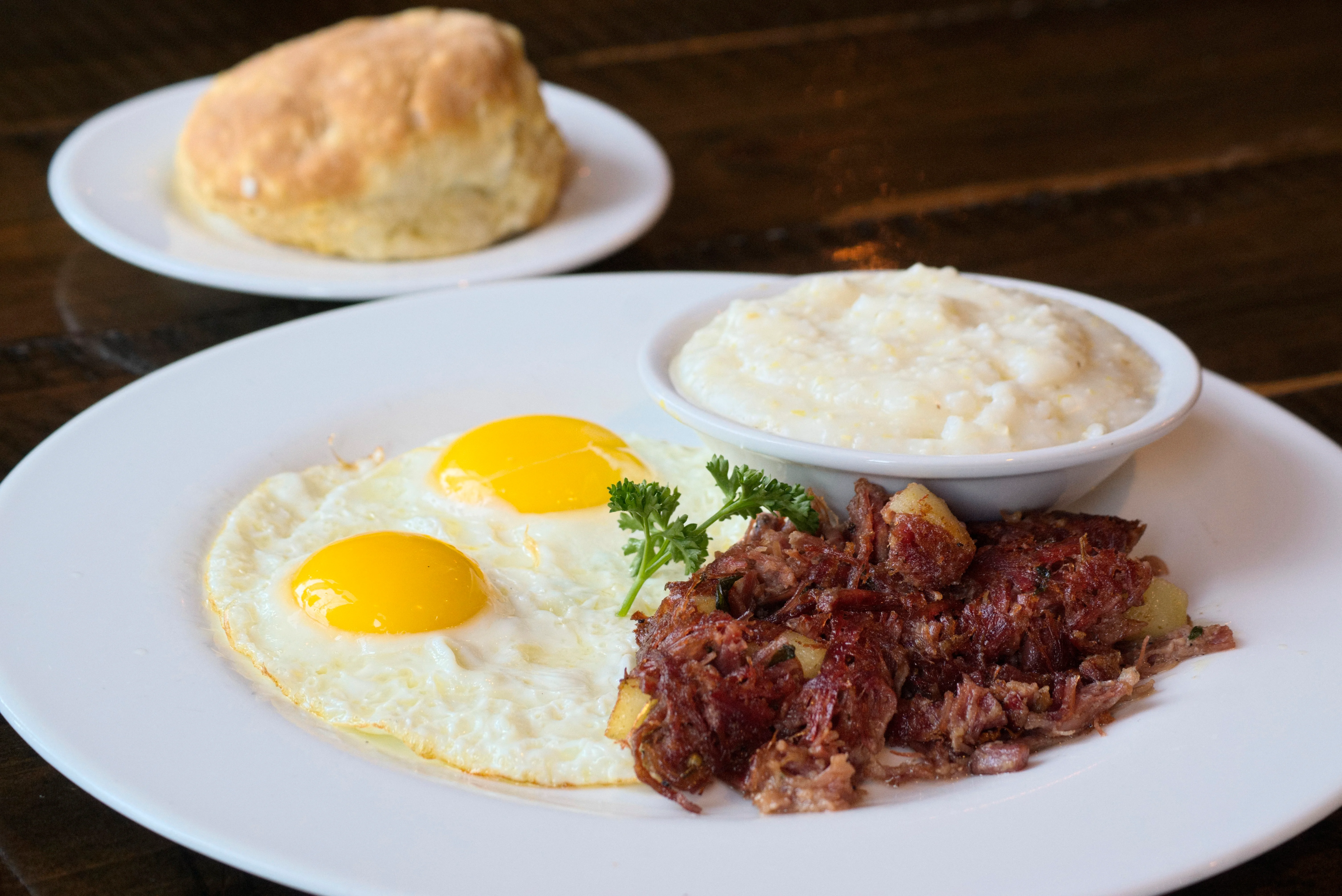 Southern breakfast plate with eggs, corned beef hash, and grits