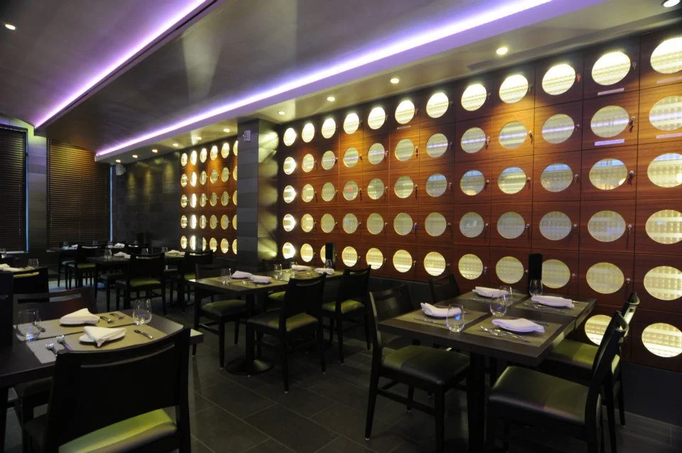 Modern restaurant interior with circular wall design and elegant table settings.