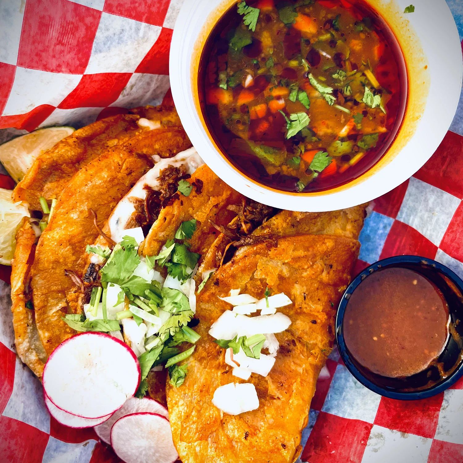 Delicious Mexican tacos with consommé and fresh toppings