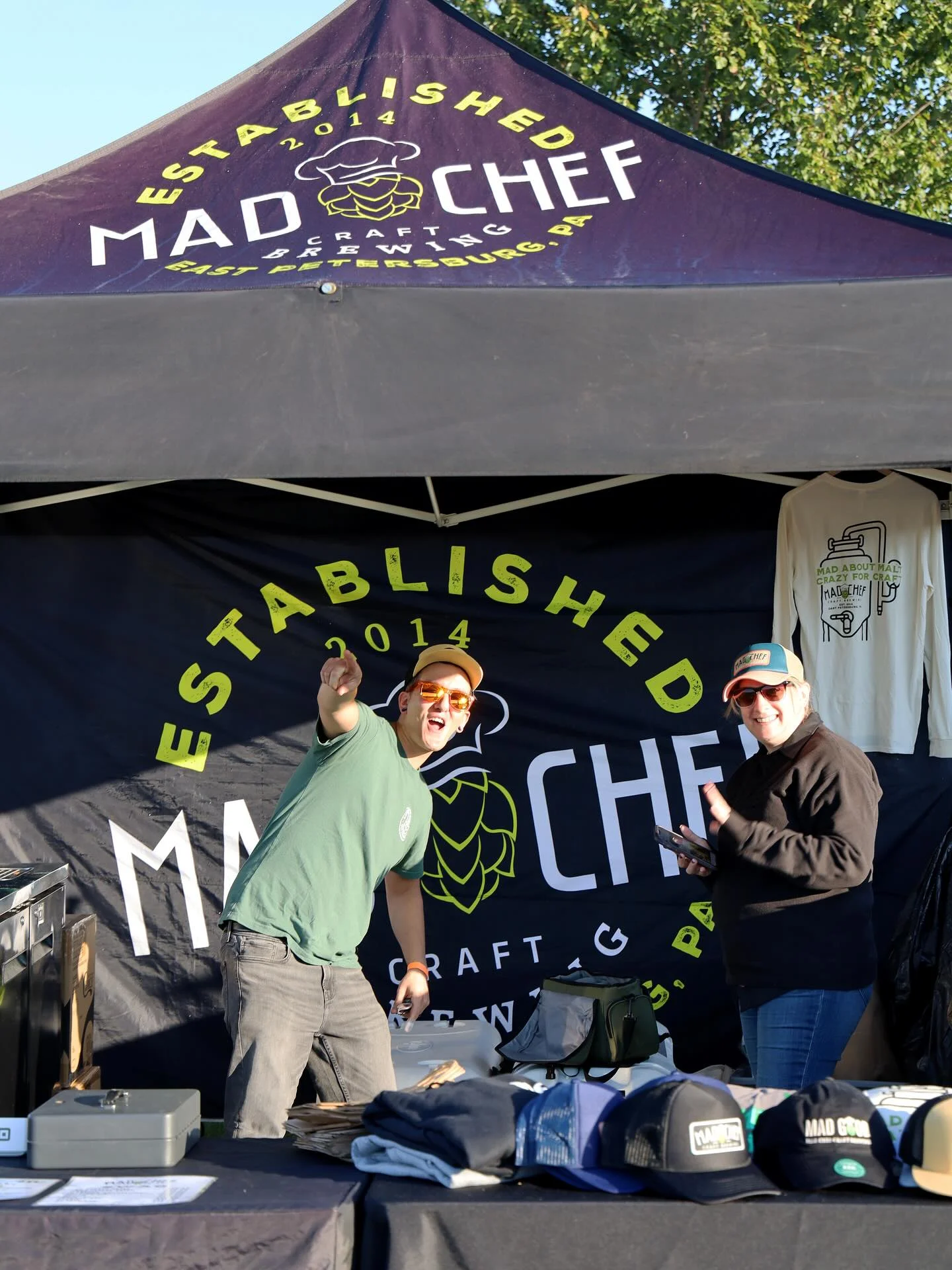 Vibrant craft brewery booth with staff engaging at an outdoor event