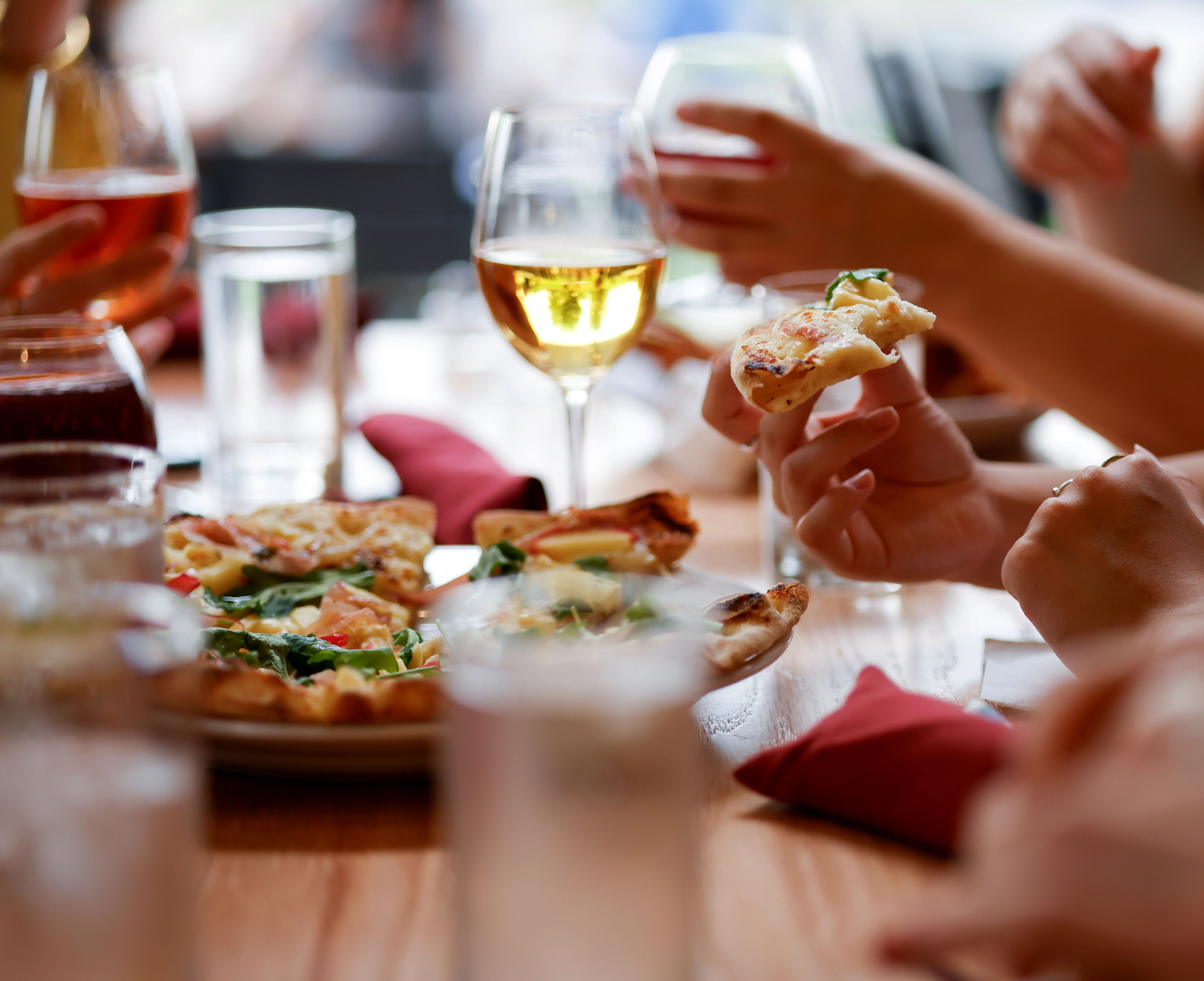 Group enjoying slices of Margherita pizza at a lively restaurant
