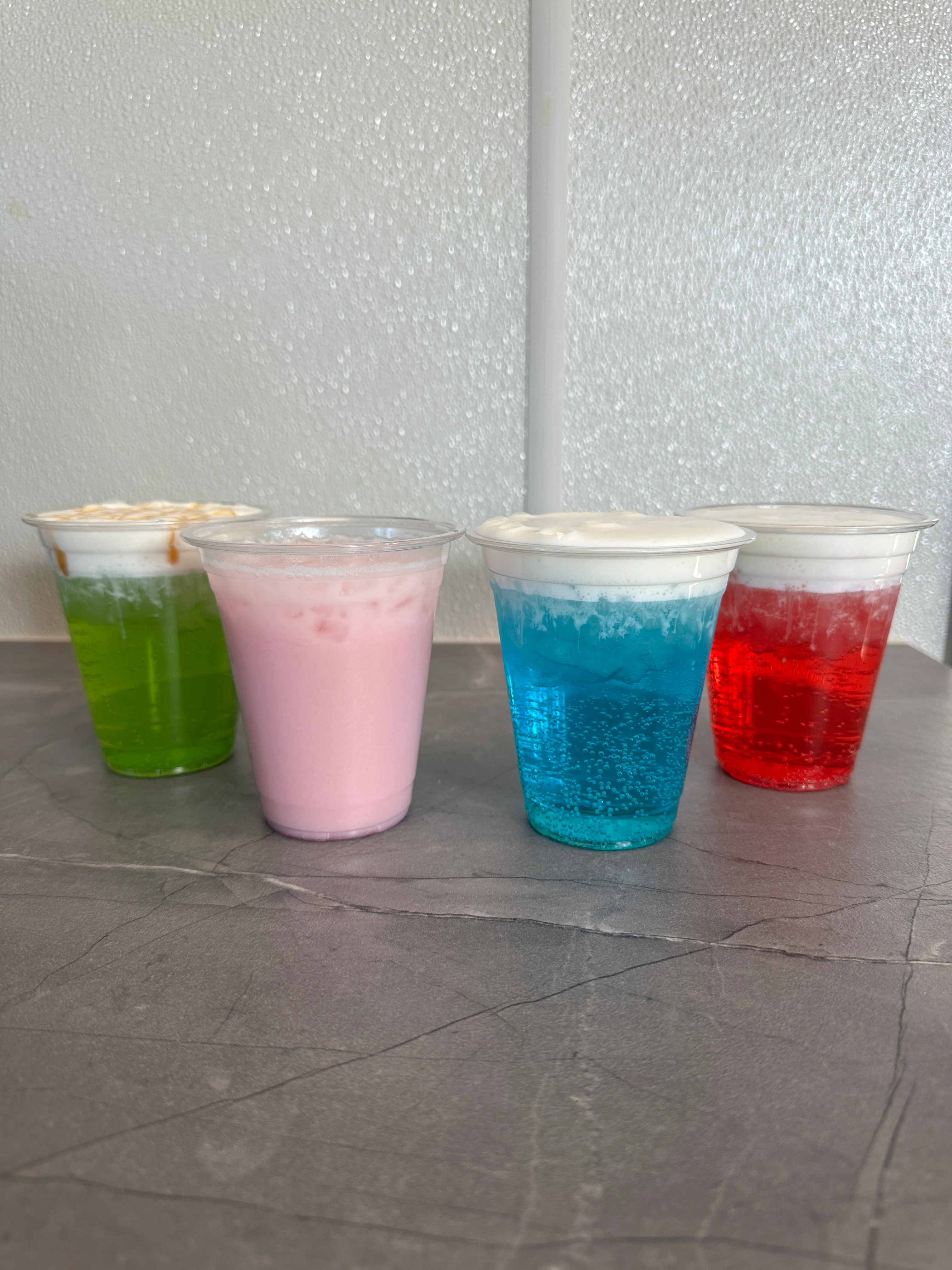 Colorful assortment of iced beverages with whipped cream toppings