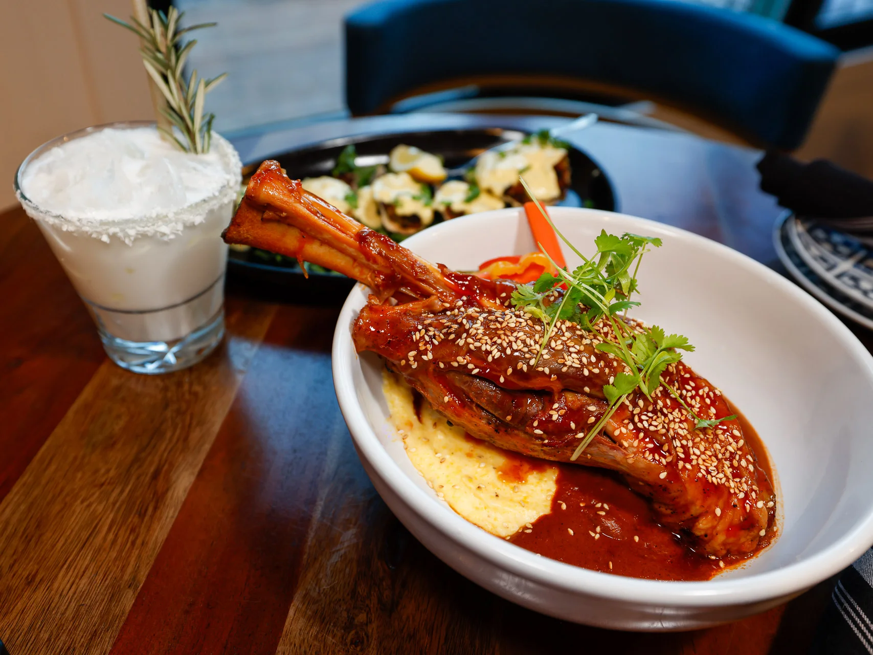 Braised Lamb Shank guajillo-honey glaze, cheddar grits, red chili mole, house pickles