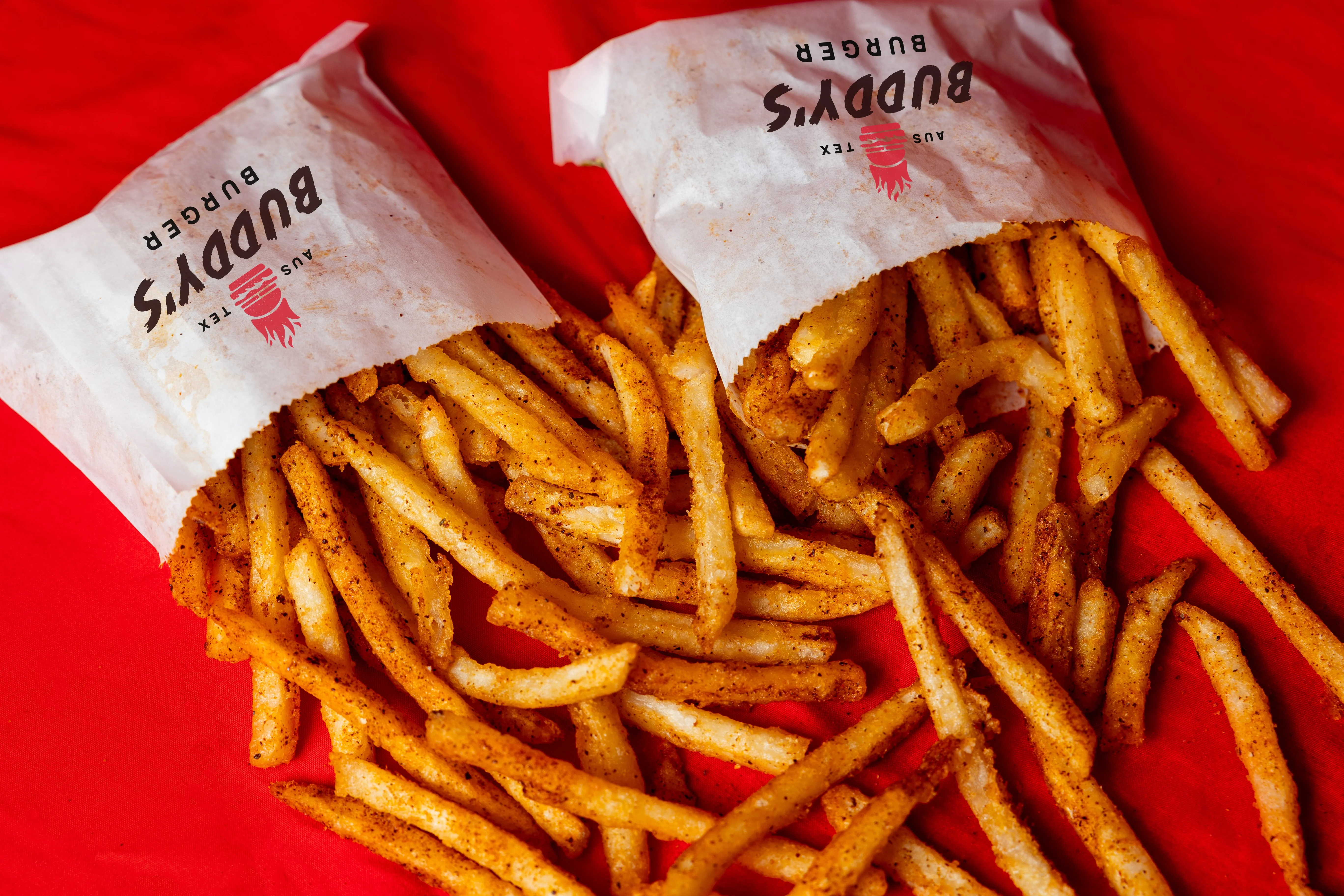 Crispy seasoned French fries in paper bags