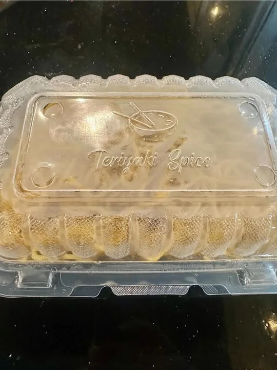A clear plastic container with a sealed lid, containing what appears to be a main dish labeled 'Teriyaki Spice'.