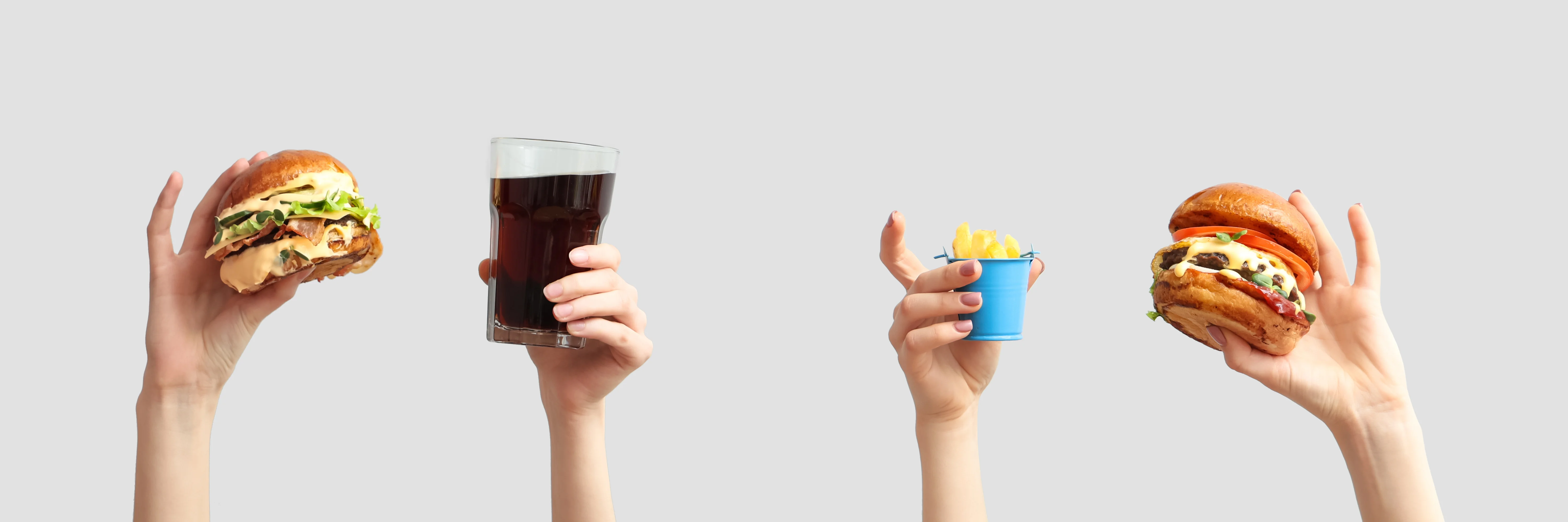 Delicious burgers and fries with a refreshing drink in hand