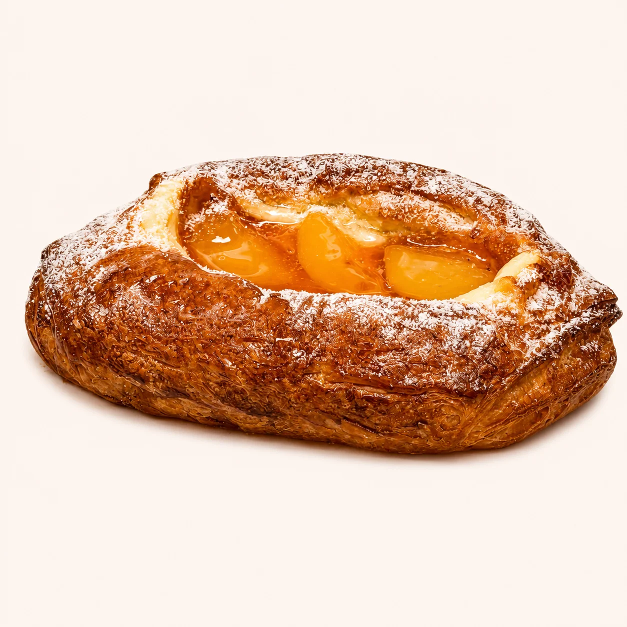 A golden-brown pastry filled with peach slices and dusted with powdered sugar.