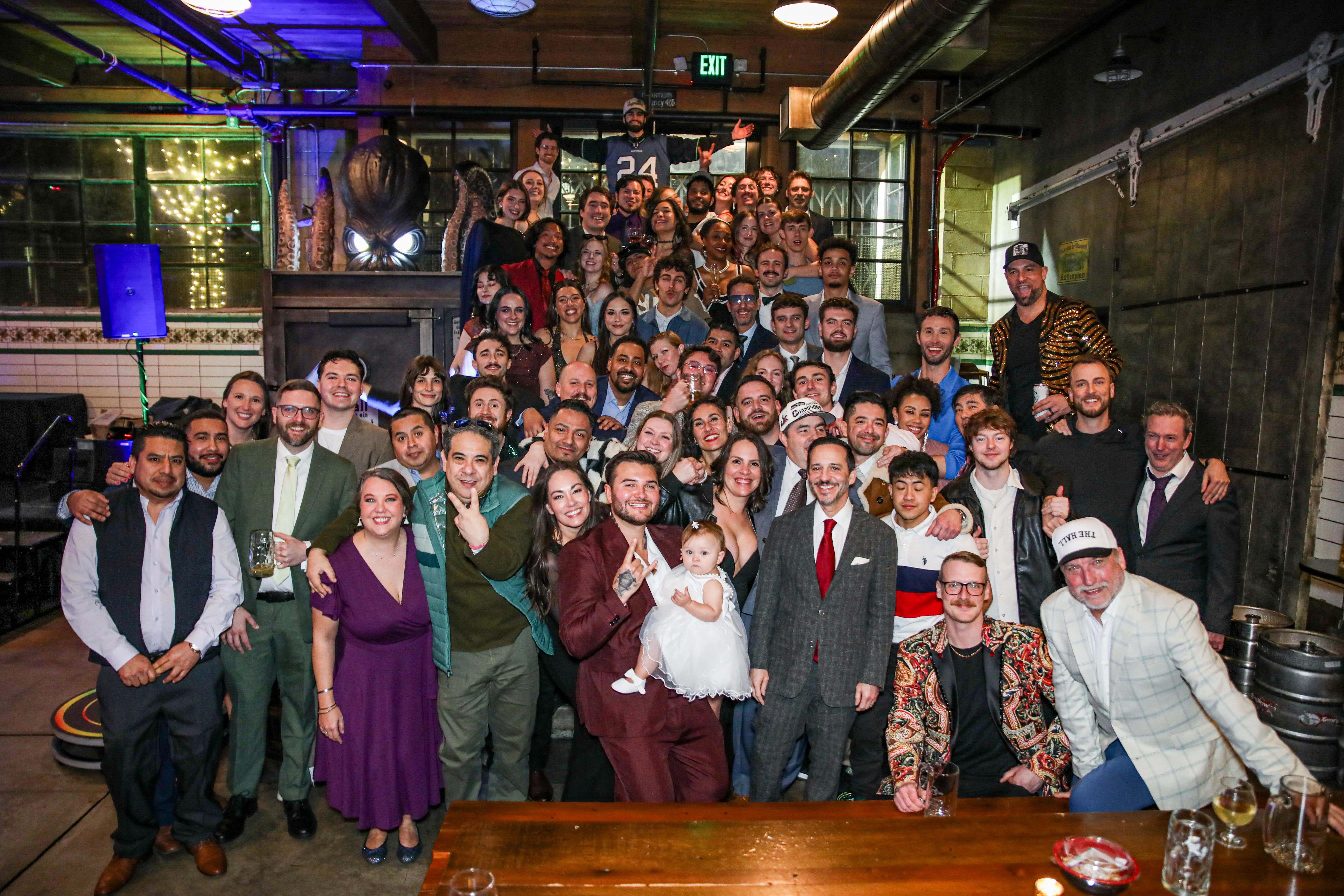 Group photo of a lively celebration in a restaurant setting