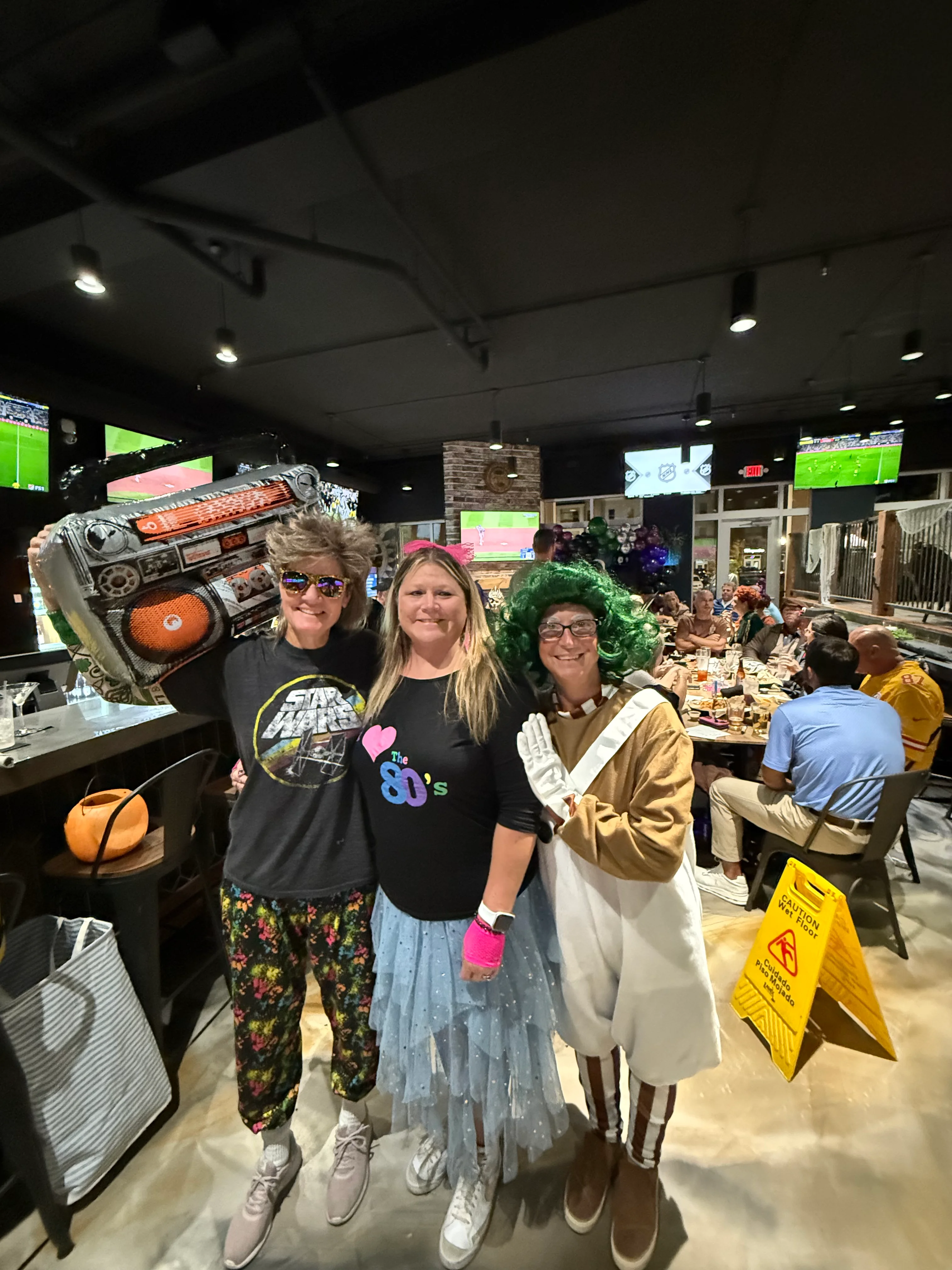 Guests in 80s costumes enjoying a lively restaurant atmosphere