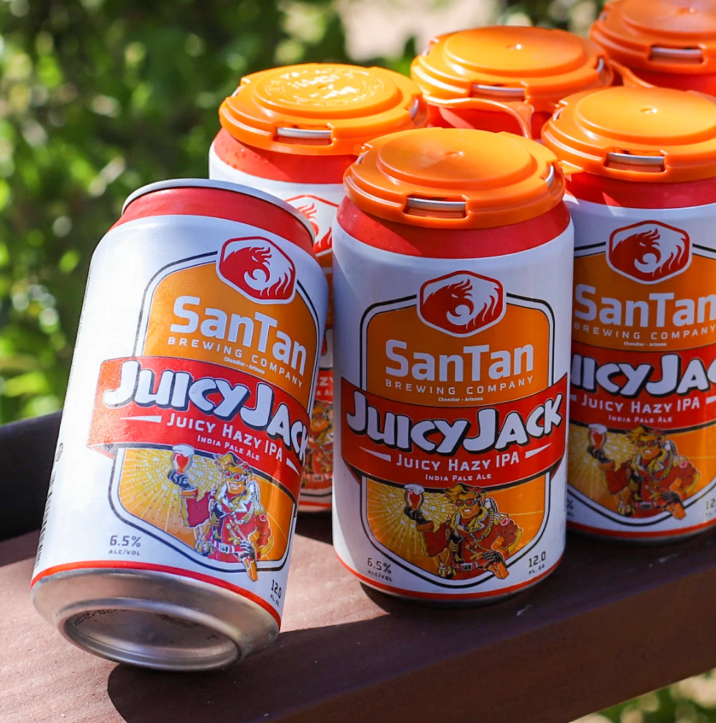 Cans of SanTan Juicy Jack Hazy IPA on a wooden table