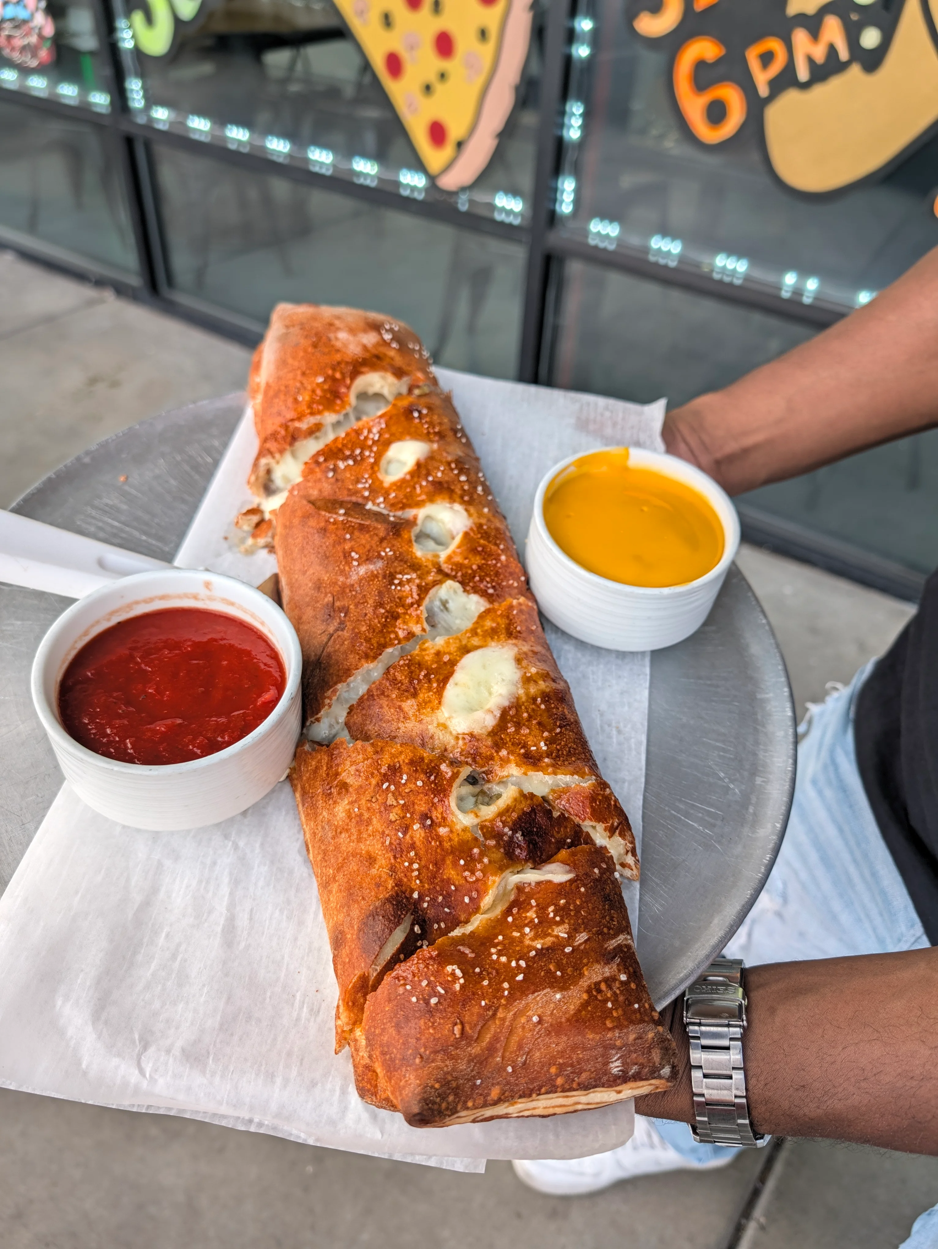 Delicious calzone served with marinara and cheese sauce