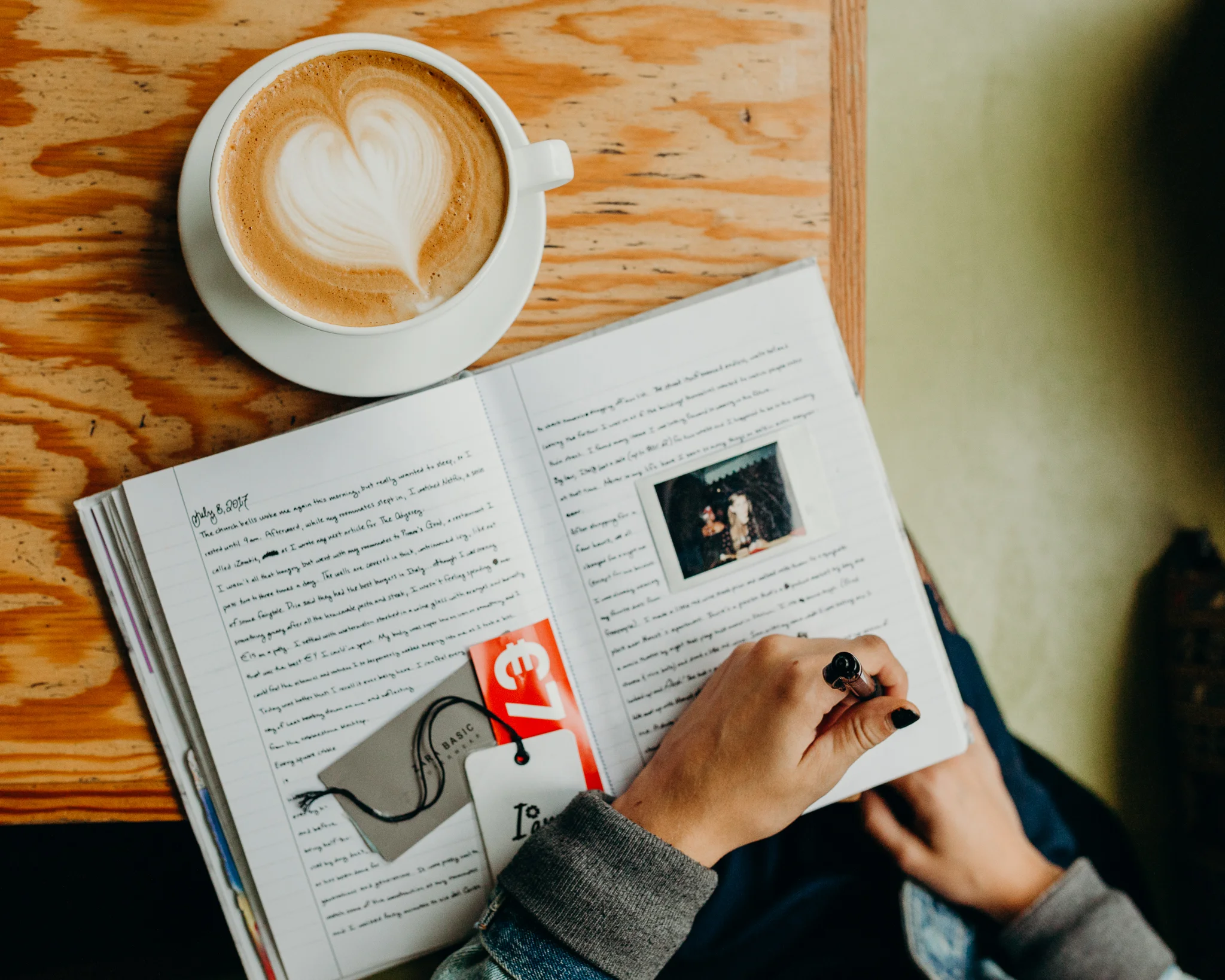 Coffee latte art with a journal on a wooden table