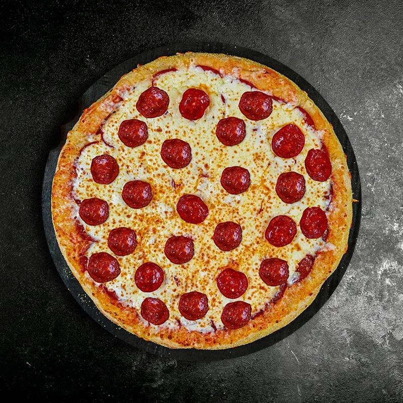 Classic pepperoni pizza on a black stone surface