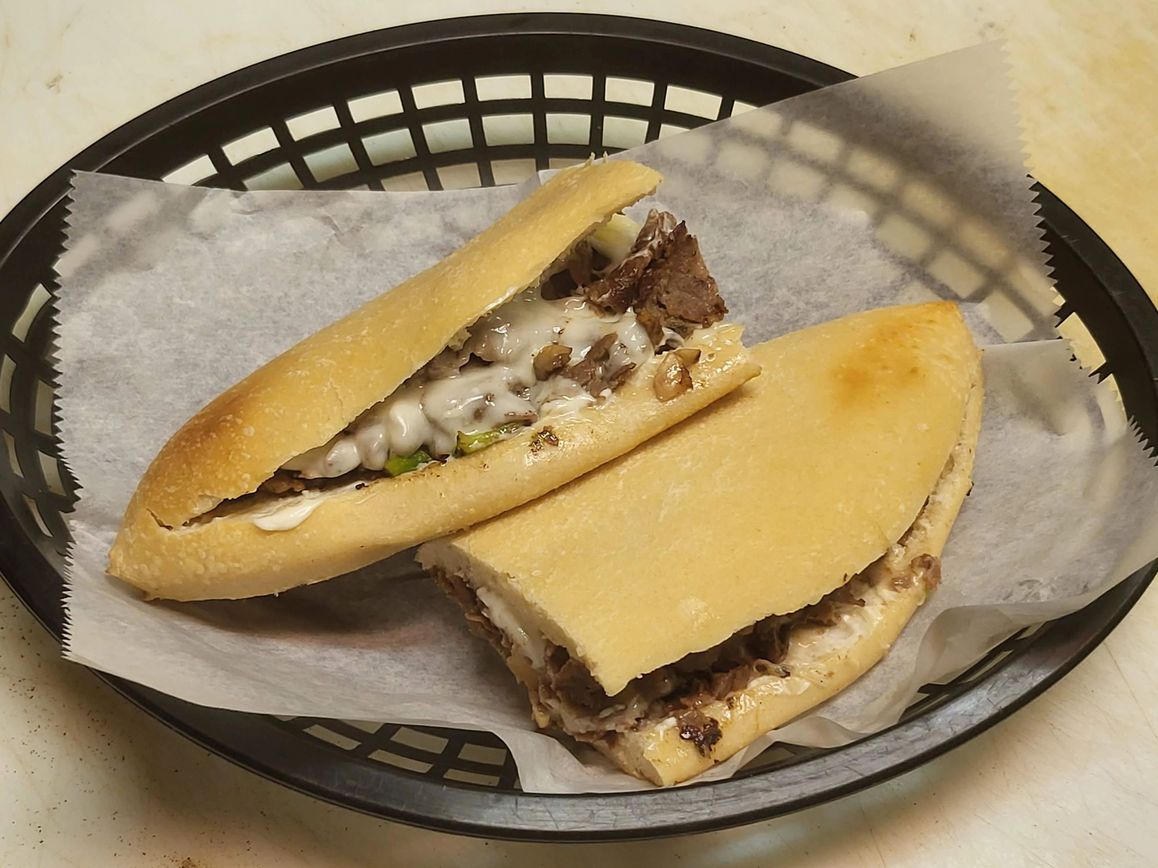 Philly cheesesteak sandwich served in a basket