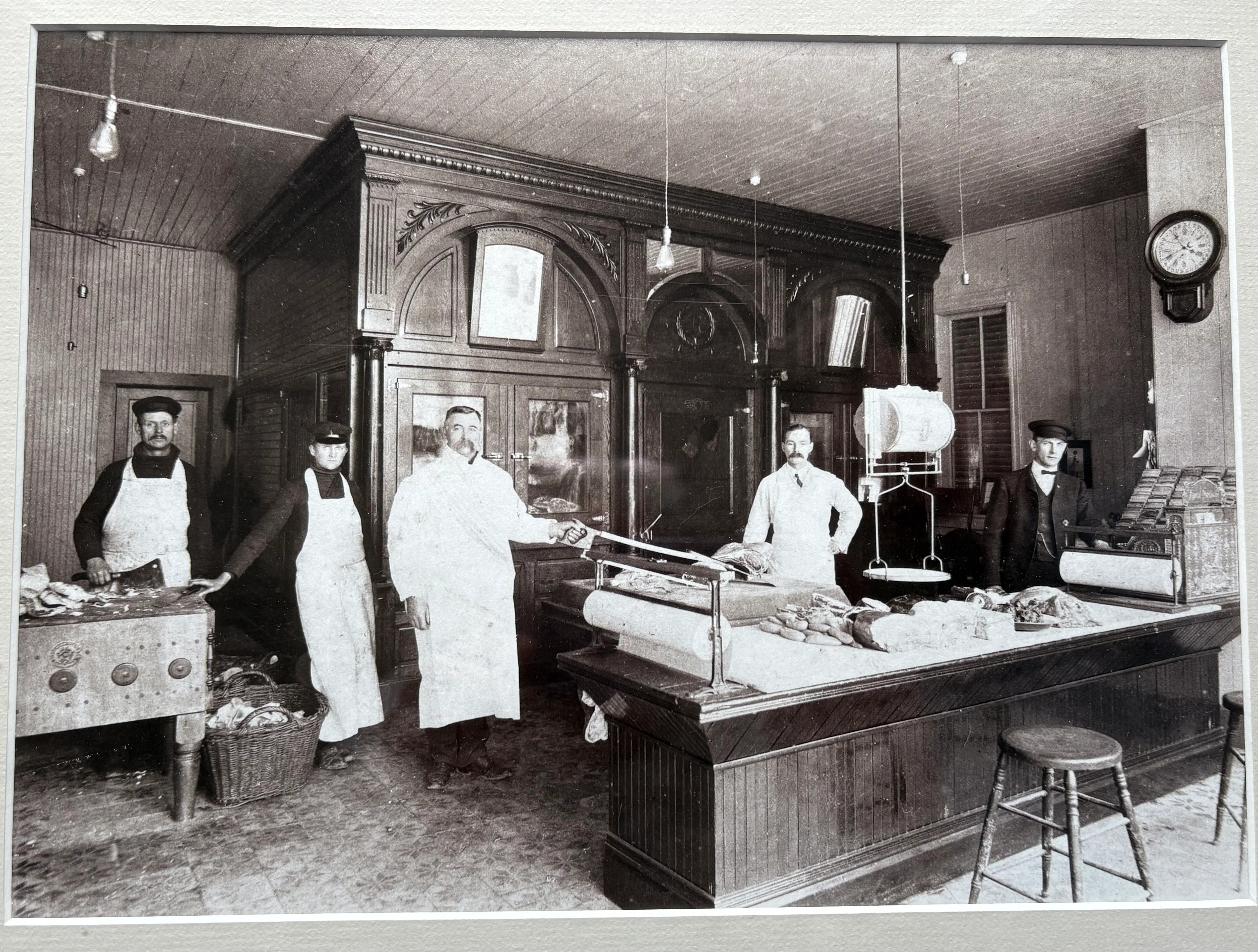 Historic butcher shop interior with staff and meat display