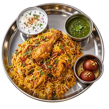 Indian chicken biryani platter with raita, chutney, and gulab jamun
