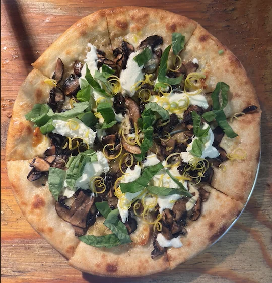 Wood-fired mushroom pizza with fresh basil and creamy ricotta