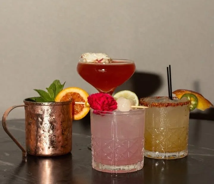 Colorful cocktails on a bar top with garnishes