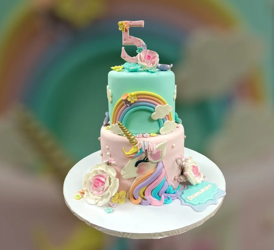 Colorful unicorn birthday cake with rainbow and floral decorations