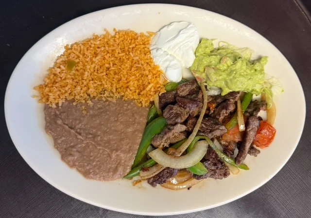 Sizzling fajitas platter with rice and beans